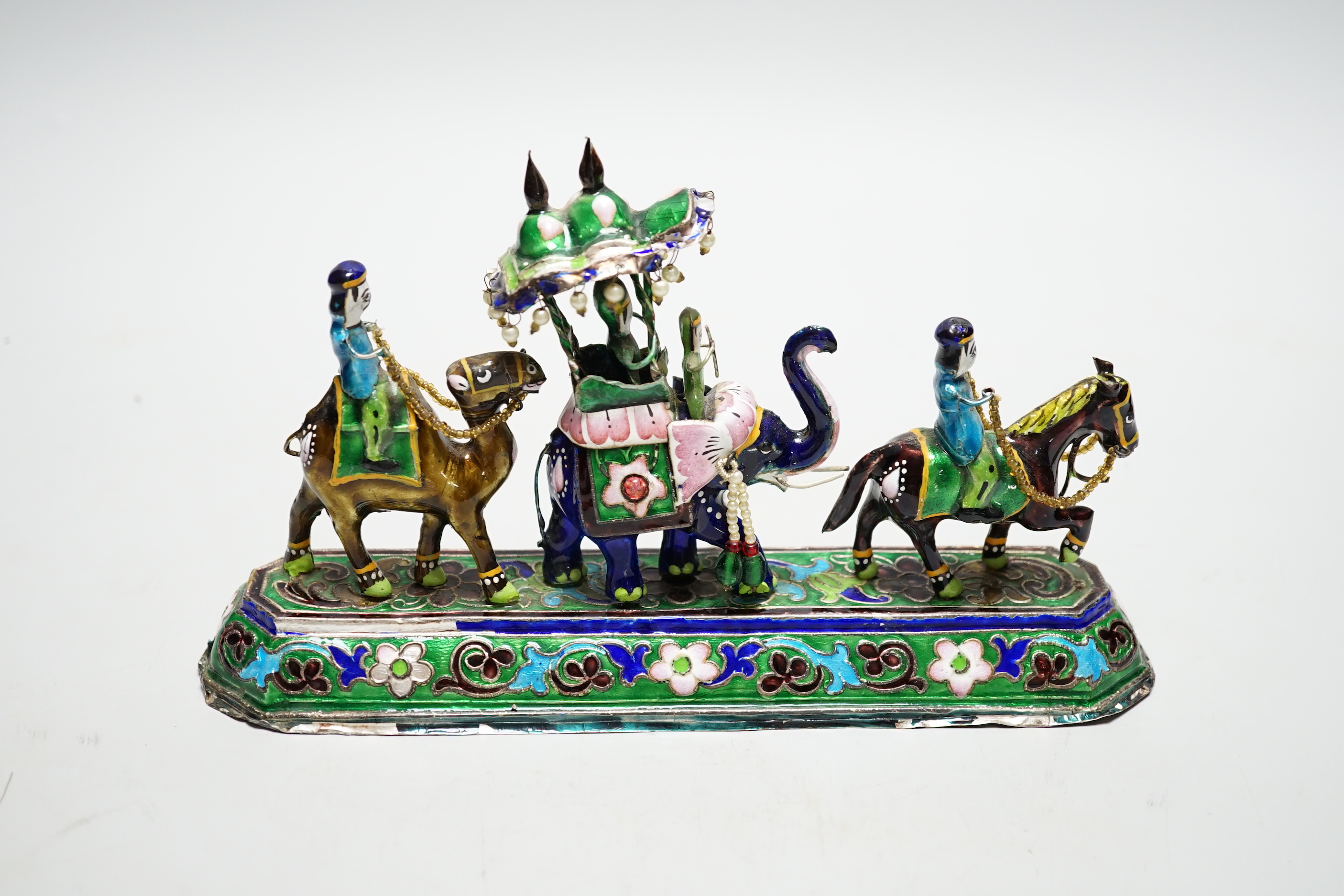 A 20th century Indian white metal and polychrome enamel figural group, with elephants and figures, stamped to base 'BHI SILVER', weighted, length 23cm.